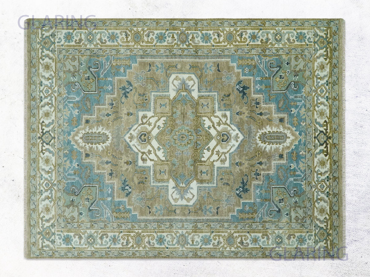 Pale blue heriz medallion rug with an ivory and taupe stepped center and blue vine border.