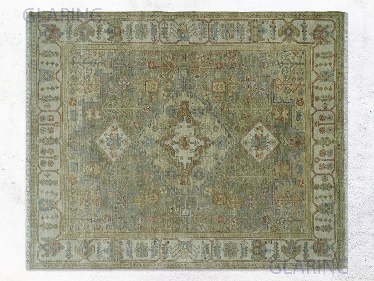 Muted olive antique heriz rug with a faint stepped medallion, side diamonds, and ivory border.