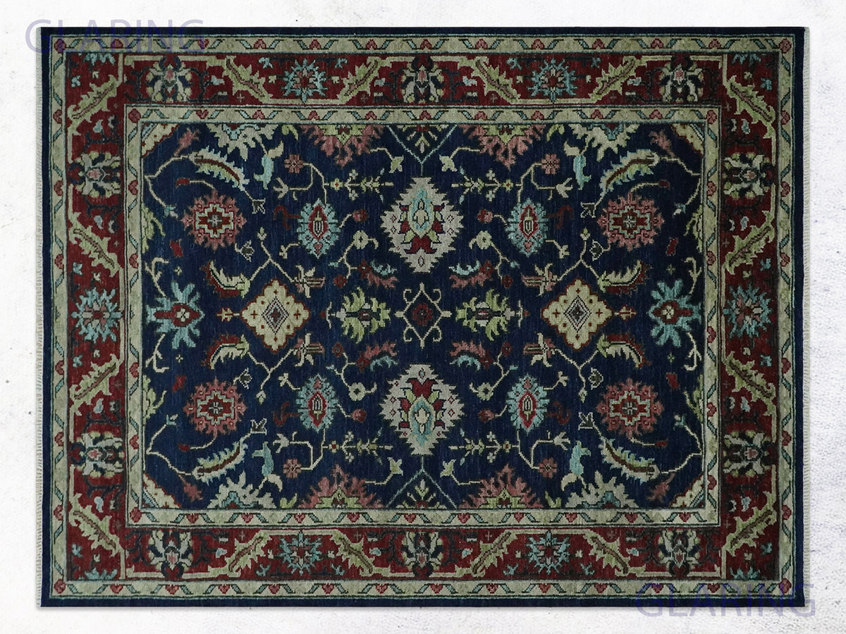 Navy burgundy persian floral rug with rose and sage sprays on a midnight field.