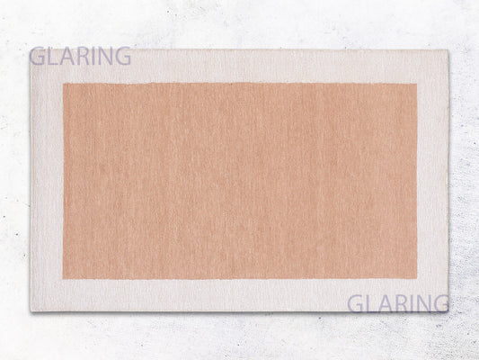 A rectangular rug with a border loop design in rust and ivory colors, with the brand name 'GLARING' visible at the top and bottom.