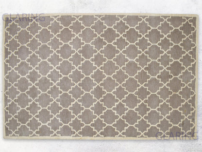A rectangular, handmade rug with a geometric design in brown and ivory colors, indicating a handmade Moroccan style.