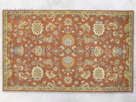 A handcrafted Oushak area rug with a geometric pattern in rust, ivory, and blue colors, featuring a medium-cut pile.