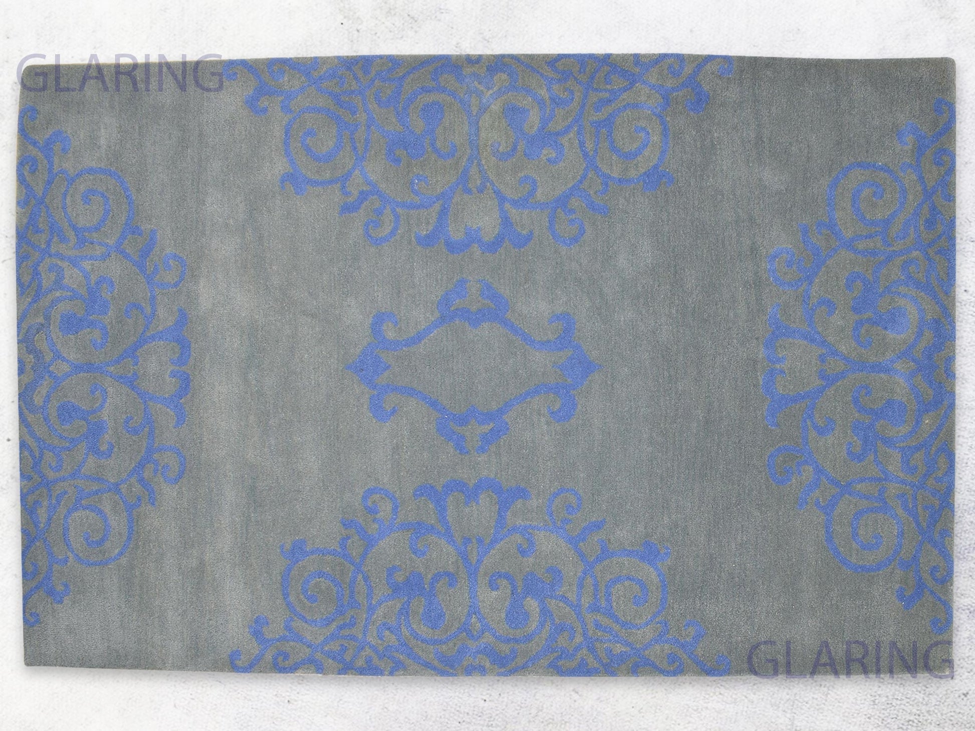 A rectangular rug with a floral design in grey and blue, with a soft medium-cut pile height.