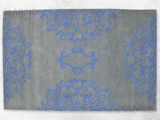 A rectangular rug with a floral design in grey and blue, with a soft medium-cut pile height.