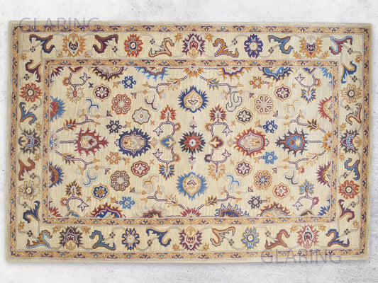 A rectangular, handmade Bohemian rug with an Oriental design featuring geometric and floral patterns in beige, blue, and red colors.